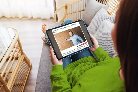 Žena sedí na gauči s tabletem