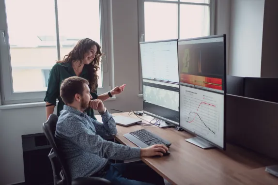 Muž a žena se dívají na monitory