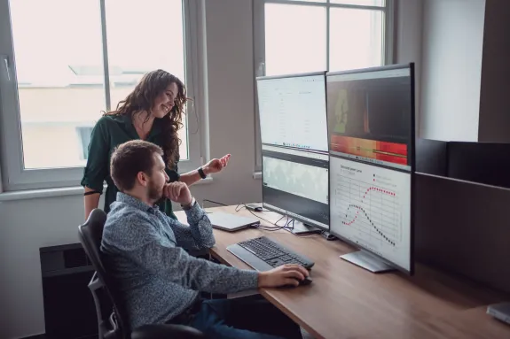 Muž a žena se dívají na monitory